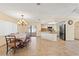 Open-concept dining room with chandelier, flowing into a kitchen featuring tiled floors, a refrigerator, and natural light at 11207 Allwood St, Spring Hill, FL 34609