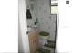 View of a half bathroom with decorative wallpaper, tiled floors, and a commode with a green lid at 11326 Brightridge Dr, Seffner, FL 33584