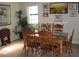 Well-lit dining room featuring a wooden table, six chairs, tile flooring, and plants by the windows at 11326 Brightridge Dr, Seffner, FL 33584