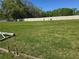Expansive grassy yard surrounded by a white fence and scattered pipes, showcasing the property's spacious outdoor area at 11326 Brightridge Dr, Seffner, FL 33584