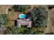 Aerial view of home featuring a pool, wooded area, and surrounding trees at 11327 Carter Grove Ln, Thonotosassa, FL 33592