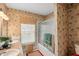 Bathroom with double vanity, shower over bath, and tropical wallpaper at 11327 Carter Grove Ln, Thonotosassa, FL 33592