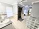 Bathroom featuring double sinks, tiled floors, glass block window and walk-in shower at 11327 Carter Grove Ln, Thonotosassa, FL 33592