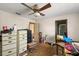 Bedroom shows ceiling fan and lighting fixture, with open door on cluttered room at 11327 Carter Grove Ln, Thonotosassa, FL 33592