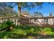 Side exterior view of home featuring an attached garage, neutral paint, and lush landscaping at 11327 Carter Grove Ln, Thonotosassa, FL 33592