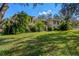 Sprawling two-story home with lush landscaping, palm trees, and a well-manicured lawn at 11327 Carter Grove Ln, Thonotosassa, FL 33592