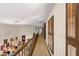 Upstairs hallway with carpet, shutters, and wood railing at 11327 Carter Grove Ln, Thonotosassa, FL 33592