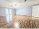 A well lit living room with neutral colors and wood floors with a door that goes to the backyard at 11327 Carter Grove Ln, Thonotosassa, FL 33592