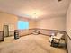Traditional living room featuring patterned wallpaper, plush carpeting, and a comfortable rocking chair at 11327 Carter Grove Ln, Thonotosassa, FL 33592