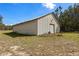 Exterior of metal outbuilding with large roll-up door on a grassy lawn at 11327 Carter Grove Ln, Thonotosassa, FL 33592