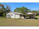 Exterior of white outbuilding with a carport attached on a grassy lawn at 11327 Carter Grove Ln, Thonotosassa, FL 33592