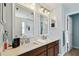 Bathroom featuring a double sink vanity, three mirrors, and ample lighting at 12017 Citrus Leaf Dr, Gibsonton, FL 33534