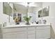 Bright bathroom featuring double sinks with quartz countertop, large mirror, and modern fixtures at 1241 Florablu Dr, Seffner, FL 33584