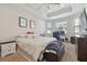 Spacious primary bedroom featuring a tray ceiling, carpeting, and dual windows for natural light at 1241 Florablu Dr, Seffner, FL 33584