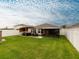 Spacious, fenced backyard with a pergola-covered patio, grill, and green lawn at 12635 Tannencrest Dr, Riverview, FL 33579
