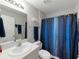 Cozy bathroom featuring vanity with sink and a shower with a blue curtain at 12635 Tannencrest Dr, Riverview, FL 33579