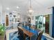 Open dining room with modern light fixture, wood table set for six and view of the kitchen and patio at 12635 Tannencrest Dr, Riverview, FL 33579