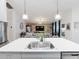 Open concept kitchen features a white quartz countertop island and stainless steel appliances overlooking the living room at 12635 Tannencrest Dr, Riverview, FL 33579
