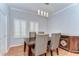 Bright dining room with wood floors, wainscotting, shuttered windows, and modern lighting at 133 S Sherrill St # 133, Tampa, FL 33609
