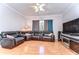 Cozy living room showcasing a plush leather sectional, wood flooring, and natural light from a nearby window at 133 S Sherrill St # 133, Tampa, FL 33609