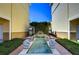 Relaxing water feature with detailed fish statues, lush greenery, and brick pavers between residential buildings at 133 S Sherrill St # 133, Tampa, FL 33609