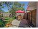 Backyard patio with table and chairs, set amongst beautiful flowers and greenery at 1740 Grove Dr, Clearwater, FL 33759