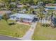 Charming single-story home featuring a metal roof, a well-manicured lawn, and tropical landscaping at 1740 Grove Dr, Clearwater, FL 33759