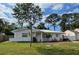 Charming single-story home with a well-maintained lawn, front yard trees, and a freshly painted exterior at 1740 Grove Dr, Clearwater, FL 33759