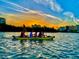 People enjoying a kayak ride on the water, scenic view of the sunset and buildings in background at 19451 Gulf Blvd # 301, Indian Shores, FL 33785