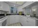Bright kitchen with white cabinetry, neutral backsplash, and stainless steel appliances at 19451 Gulf Blvd # 301, Indian Shores, FL 33785