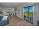 Bright living room features dining area, balcony access with nice views, and light wood-look flooring at 19451 Gulf Blvd # 301, Indian Shores, FL 33785
