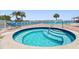 Relaxing pool area with a hot tub, lounge chairs, and palm trees, perfect for outdoor enjoyment at 19451 Gulf Blvd # 301, Indian Shores, FL 33785