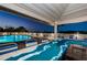 Community pool with lounge chairs and bar seating overlooking serene water views at twilight at 19451 Gulf Blvd # 301, Indian Shores, FL 33785