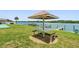 Beautiful waterfront recreation area with picnic table, shuffle board, dock, and serene water views at 19451 Gulf Blvd # 301, Indian Shores, FL 33785
