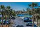 A view of the tennis courts and parking area framed by mature palm trees at 19451 Gulf Blvd # 301, Indian Shores, FL 33785