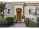 Elegant front entrance with stone accents, a secure wrought iron gate, and manicured landscaping at 2216 Soho Bay Ct, Tampa, FL 33606