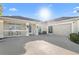 Beige single-story home with a driveway, two-car garage, and a front porch with white railings at 2325 W Del Webb Blvd, Sun City Center, FL 33573