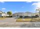 Tan one-story home with landscaped front yard and driveway with a white decorative lamp post at 2325 W Del Webb Blvd, Sun City Center, FL 33573