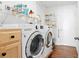 Well-lit laundry room with LG washer and dryer, storage cabinets, overhead shelving, and decorative wall accents at 2325 W Del Webb Blvd, Sun City Center, FL 33573