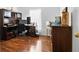 Home office featuring hardwood floors, built-in shelving, and plenty of natural light at 2325 W Del Webb Blvd, Sun City Center, FL 33573