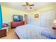 Bedroom with a flat screen TV, double closets, and wood look floors at 245 Grove Cir N, Dunedin, FL 34698