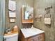 Stylish bathroom with wood vanity, marble countertop and creative olive green wallpaper at 24862 Us Highway 19 N # 1701, Clearwater, FL 33763