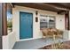 Charming front porch featuring a vibrant blue door, seating, and manicured landscaping at 24862 Us Highway 19 N # 1701, Clearwater, FL 33763