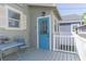 Back porch with outdoor seating features a blue door and white-trimmed windows and a small fence at 2835 3Rd N Ave, St Petersburg, FL 33713