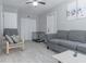 Neutral living room with a gray couch, chair, and light wood flooring, illuminated by a ceiling fan at 2835 3Rd N Ave, St Petersburg, FL 33713