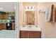 Bright half bathroom with tile flooring, vanity with sink, and decorative mirror and light fixture at 3002 Mojave Oak Dr, Valrico, FL 33594