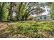 Spacious backyard featuring lush grass, mature trees, and a charming, well-maintained home at 304 E Hanlon St, Tampa, FL 33604