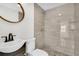 Beautiful bathroom featuring an oval mirror, tiled shower, and modern sink at 304 E Hanlon St, Tampa, FL 33604