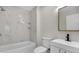 Modern bathroom with a bathtub, shower, white marble-look tile, and a sleek vanity with updated fixtures at 304 E Hanlon St, Tampa, FL 33604