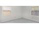 Minimalist bedroom featuring neutral walls, windows with blinds, and marble-look tile flooring at 304 E Hanlon St, Tampa, FL 33604
